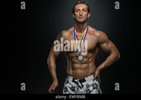 Fitness homme montrant son concurrent Médaille gagnante Banque D'Images