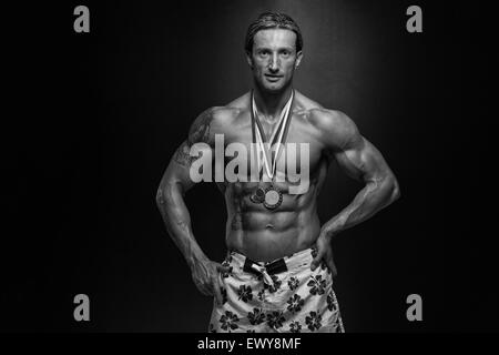 Fitness homme montrant son concurrent Médaille gagnante Banque D'Images