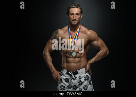 Fitness homme montrant son concurrent Médaille gagnante Banque D'Images