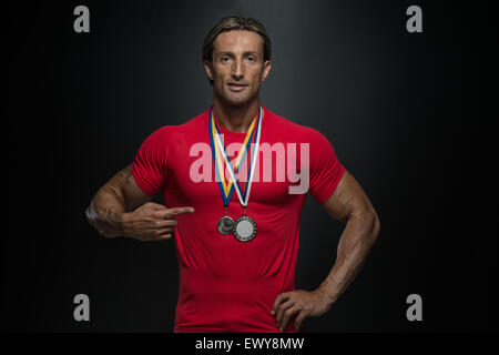 Fitness homme montrant son concurrent Médaille gagnante Banque D'Images