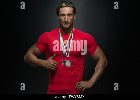 Fitness homme montrant son concurrent Médaille gagnante Banque D'Images