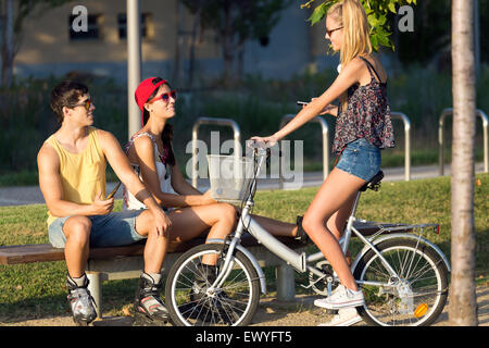 Portrait plein air de groupe d'amis avec des patins à roulettes et le vélo dans le parc. Banque D'Images