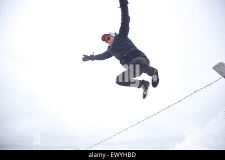 Low angle view of a young man jumping over fence Banque D'Images