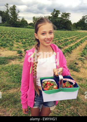 Girl Holding un panier avec des fraises fraîches Banque D'Images