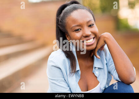 Happy young African college girl sitting outdoors Banque D'Images