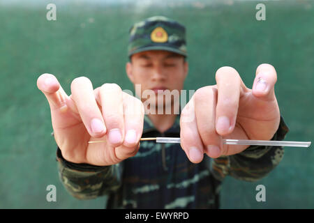 Haikou. 2 juillet, 2015. Guo Lizhen Sniper du Corps de Hainan de la Police armée du peuple chinois d'étude tente de mettre un cure-dent dans une paille avec ses yeux fermés dans un programme de formation dans le sud de la Chine La province de Hainan, le 2 juillet 2015. Tireurs d'ici généralement assister à 10 heures de formation chaque jour. © Yang Ruiming/Xinhua/Alamy Live News Banque D'Images