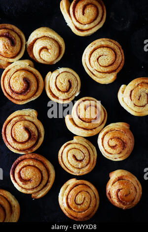 Les brioches à la cannelle sur une plaque de cuisson, vue du dessus Banque D'Images