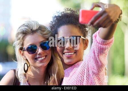 Portrait de deux étudiants de l'université de prendre une fille selfies dans la rue. Banque D'Images