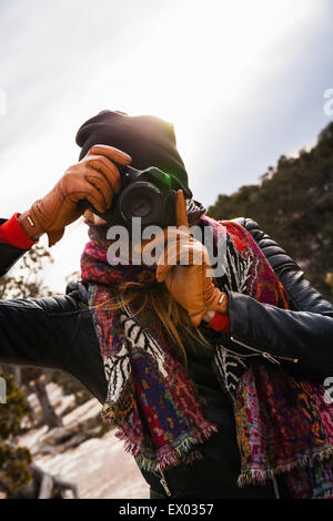 Woman photographing in front of river Banque D'Images