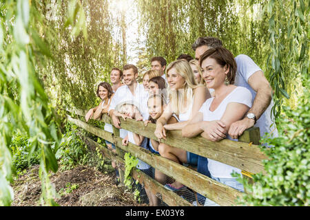 Portrait de groupe de personnes appuyé contre une clôture en forêt Banque D'Images