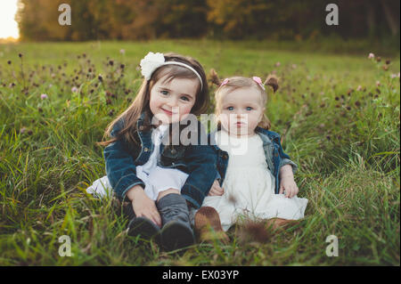 Portrait de jeune fille et petite sœur dans le champ Banque D'Images