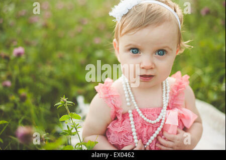 Portrait de blue eyed baby girl in meadow