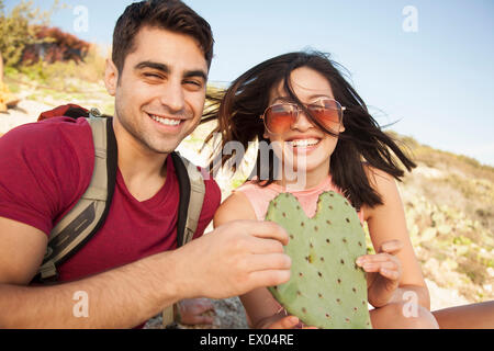 Young couple holding leaf cactus en forme de coeur Banque D'Images