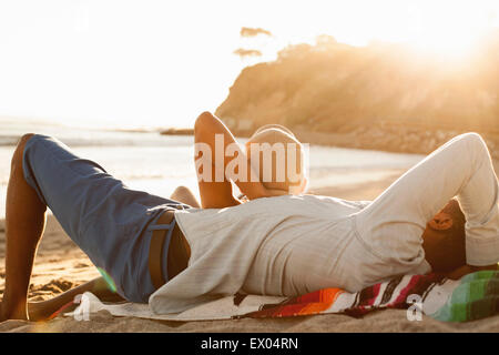 Young couple lying on beach, vue arrière Banque D'Images