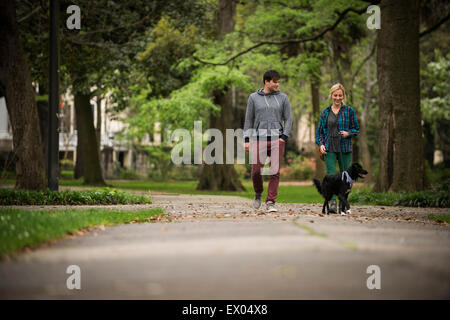 Couple walking dog in park, Savannah, Georgia, USA Banque D'Images