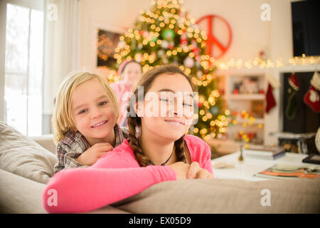 Portrait of teenage girl et frère s'appuyant sur canapé à Noël Banque D'Images