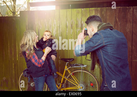 Young man photographing woman with baby boy Banque D'Images