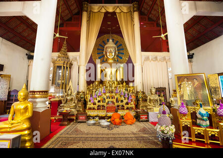 Jeunes moines en prière devant l'autel principal de l'Wiharn Luang à Wat Phra Singh, Chiang Mai Banque D'Images