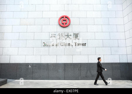 Un homme marche en face de la tour de la Banque de Chine signent à Central, Hong Kong Banque D'Images