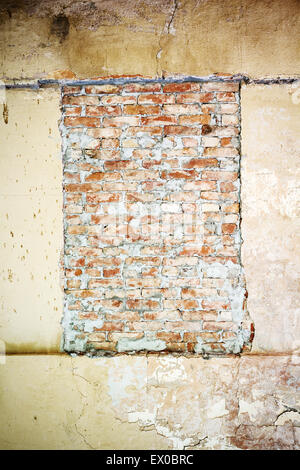 Fenêtre murée sur un vieux mur de béton Banque D'Images