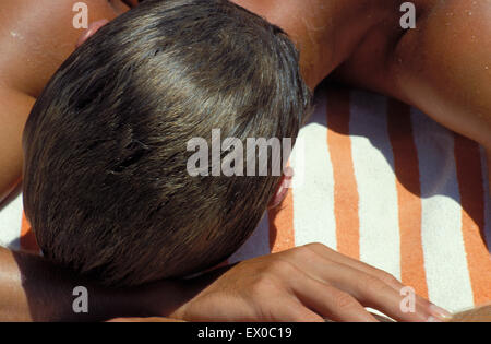 Lir, Italie, Sardaigne, bronzage homme à la plage de Sardaigne du Sud. Lir, Italie, Sardaigne, Mann beim sonnenbaden am Strand v Banque D'Images