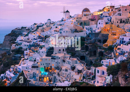La ville d'Oia au coucher de soleil sur Santorin, l'une des îles des Cyclades en mer Égée, Grèce. Banque D'Images