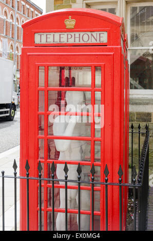 Boîte de téléphone rouge avec fullsize statue d'un homme à l'intérieur de St Giles' Square, Northampton Banque D'Images