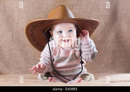 Happy laughing baby portant un cow girl costume avec un grand chapeau Banque D'Images