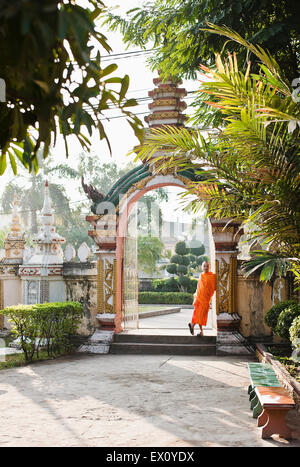 Un jeune moine se détend dans une porte à Wat Si Muang, Vientiane, Laos, P.D.R. Banque D'Images