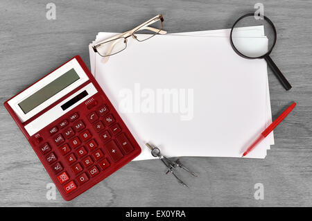 Papier blanc avec calculatrice, stylo, lunettes et loupe Banque D'Images