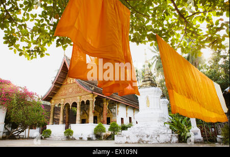 Robe safran suspendu dans la cour de la TVA. Paphaimisaiyanaram (C'est la même chose que Wat Pa Pai.) Luang Prabang, Laos. Banque D'Images