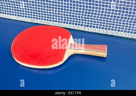 Raquette de tennis de table et filet sur une table de tennis de table bleu Banque D'Images