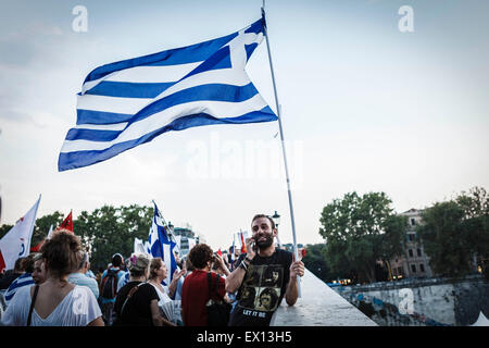 Rome, Italie. 06Th Juillet, 2015. Un manifestant brandit une drapeau grec alors qu'il prend part à un rassemblement de soutien à voter "non" lors du prochain référendum grec sur l'Union européenne d'austérité dans Rome. Des milliers de personnes, deux jours avant le référendum grec sur l'Union européenne l'austérité, prendre la rue à Rome pour soutenir le peuple grec dans sa lutte contre la troïka et sa politique d'austérité. Credit : Giuseppe Ciccia/Pacific Press/Alamy Live News Banque D'Images