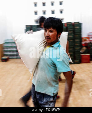 (150704) -- PISHAN, le 4 juillet 2015 (Xinhua) -- Un bénévole porte secours à un entrepôt à un centre de secours en cas de catastrophe à l'école professionnelle secondaire Pishan dans quake-hit Pishan Comté de Hotan, préfecture du nord-ouest de la Chine La région autonome du Xinjiang Uygur, le 3 juillet 2015. Un séisme de magnitude 6,5 a secoué la Préfecture de Pishan Comté de Hotan à 9:07 heures (GMT), 0107avec l'épicentre enregistré à 37,6 degrés nord et 78,2 degrés est, selon le séisme en Chine Centre Réseaux (CENC). Du matériel de secours sont en cours pour le séisme a frappé les régions. (Xinhua/Ma Kai) (lfj) Banque D'Images