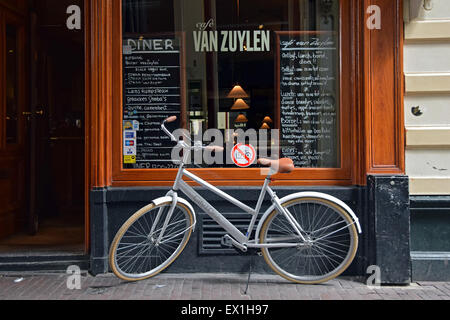 Un vélo garé à côté d'un des vélos aucun signe devant Cafe Van Zuylen sur Torensteeg rue d Amsterdam, Holland Banque D'Images