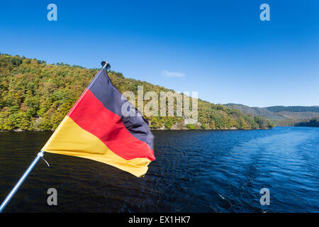 Drapeau allemand sur un bateau sur le Lac Rursee Avec ciel bleu et du soleil en été. Banque D'Images