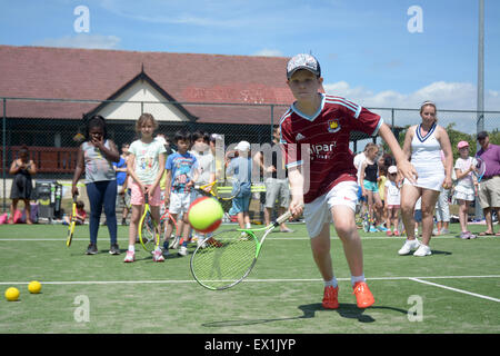 Les enfants jusqu'à la ligne avec succès à Wimbledon tennis stars britanniques Park à mi-chemin du tennis de Wimbledon Banque D'Images