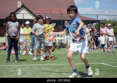 Les enfants jusqu'à la ligne avec succès à Wimbledon tennis stars britanniques Park à mi-chemin du tennis de Wimbledon Banque D'Images