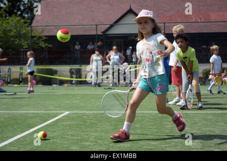 Les enfants jusqu'à la ligne avec succès à Wimbledon tennis stars britanniques Park à mi-chemin du tennis de Wimbledon Banque D'Images