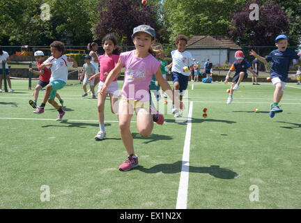 Les enfants jusqu'à la ligne avec succès à Wimbledon tennis stars britanniques Park à mi-chemin du tennis de Wimbledon Banque D'Images