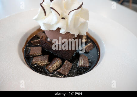 Gâteau fondant au chocolat et la crème glacée sur la sauce au chocolat et crème fouettée avec gaufre sur le dessus Banque D'Images