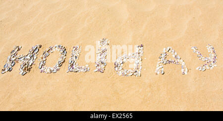 Maison de vacances "Word" fait de coquillages sur le sable jaune. Banque D'Images