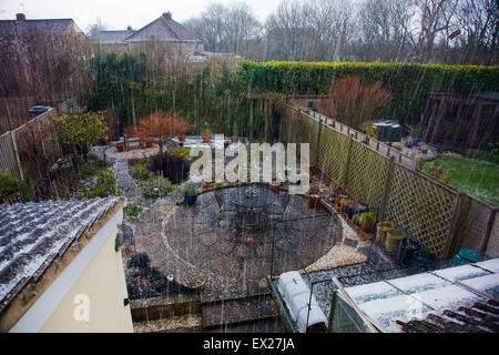 Une puissante tempête de grêle tombe sur un jardin arrière en Cossington, Somerset, England, UK Banque D'Images