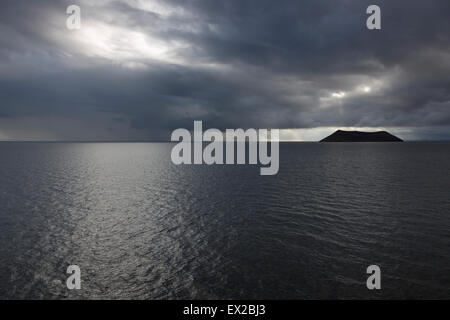 Des averses de pluie et ciel menaçant près de l'île de Daphné au coucher du soleil Banque D'Images