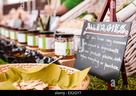 Sign at a market stall avise les personnes allergiques à vérifier avec le personnel avant l'échantillonnage ou à l'achat. Banque D'Images