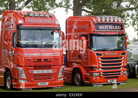 Les cabines de camion Volvo et Mercedes garé sous les arbres à un show ground en Angleterre Banque D'Images