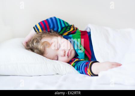 Funny Girl à dormir dans un lit blanc Banque D'Images