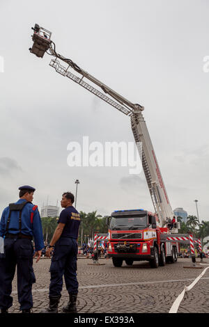 Un camion de feu à plaque tournante de type échelle est photographié au premier plan des pompiers lors d'une répétition par la brigade des pompiers de Jakarta à Jakarta, en Indonésie. Banque D'Images