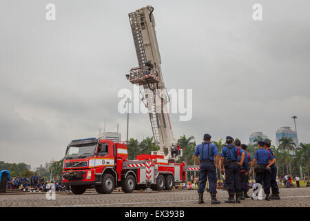 Un camion de feu à plaque tournante de type échelle est photographié au premier plan des pompiers lors d'une répétition par la brigade des pompiers de Jakarta à Jakarta, en Indonésie. Banque D'Images