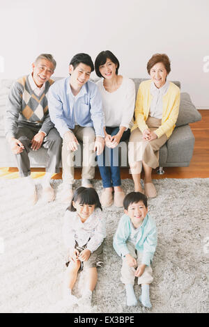 Trois générations de la famille japonaise sur le canapé dans le salon Banque D'Images